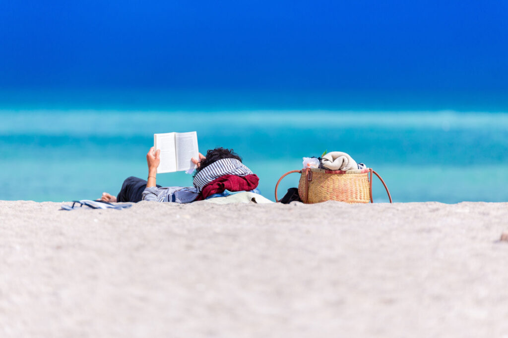 person reading a book on the beach