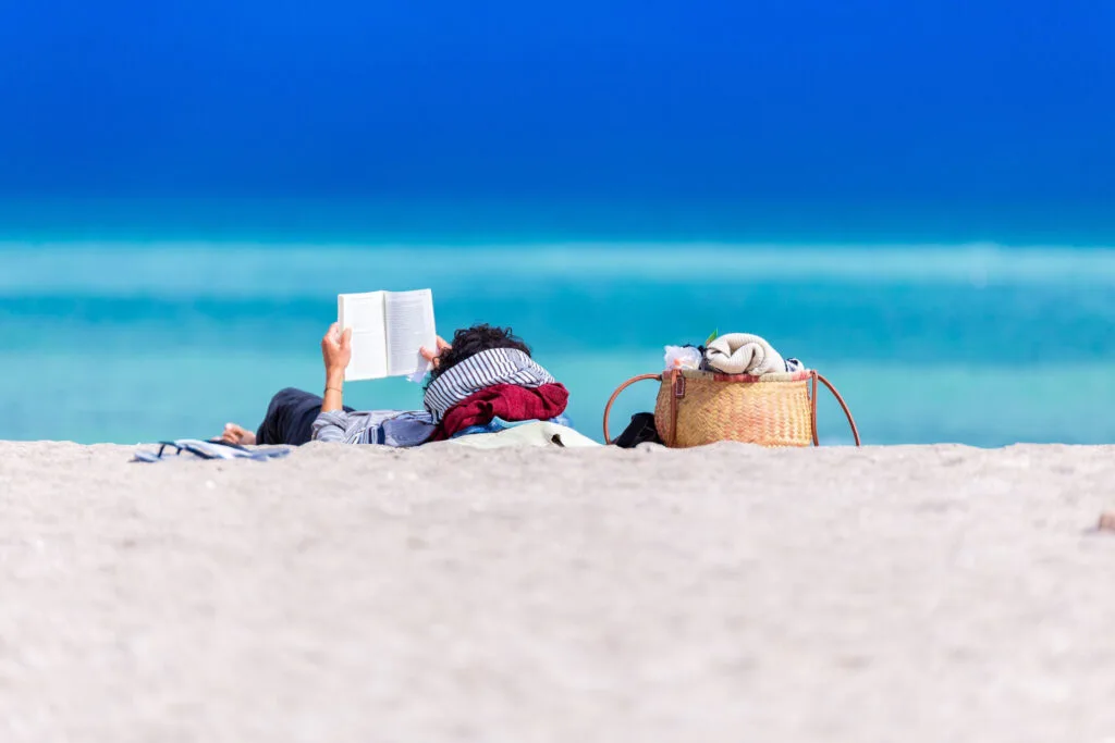person reading a book on the beach